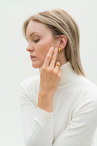 Model wearing sustainable jewelry earrings & ring